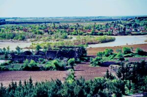 Aspendos yakınlarında, 17 Nisan 1984 tarihinde çekilmiş, muhtemelen Köprüsuyu Hanı'na ait bir kervansaray kalıntısının görüntüsü. Arka planda taş duvarlar ve yıkık yapılar dikkat çekiyor.